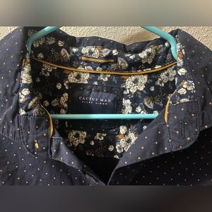 This is a blue button down shirt with gold dots around them